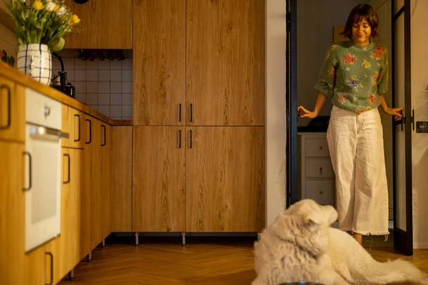 Nainen Kävelee Keittiössä Huoneessa Tervehtii Koiransa Makaa Tyylikäs Kodin Sisustus — kuvapankkivalokuva