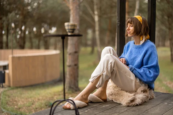 Young Woman Sits Porch Wooden House Pine Forest Enjoying Nature — kuvapankkivalokuva