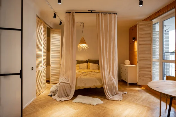 用自然材料制成的米色色调的时尚工作室公寓的内部视图 带天篷的卧室区 — 图库照片