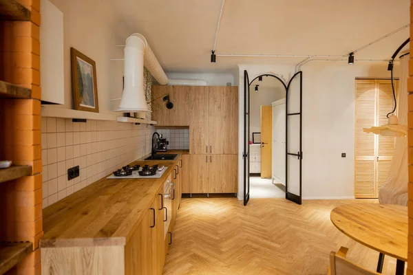 用现代工作室公寓木制材料制作的时尚厨房内部的照片 橡木厨房立面和金属拱门 — 图库照片
