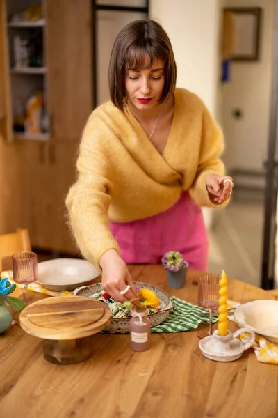 女人装饰一张餐桌 准备在家里吃一顿喜庆而浪漫的晚餐 — 图库照片