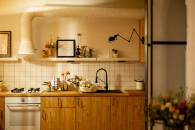 Modern mutfak iç dekorasyonu, ahşap cephelerden ve çiçeklerle süslenmiş açık raflardan yapılmış doğal malzemelerden yapılmıştır. Ev dekorasyonu ve tasarım konsepti