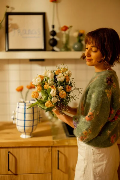 漂亮的女人在家里的厨房里做一束花 用鲜花装饰她的现代公寓 — 图库照片