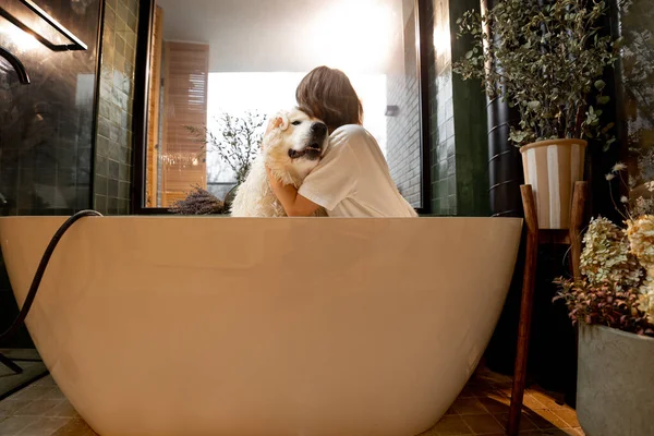 Young Woman Hugs Her Cute Dog Bathtub Spa Procedures Bathroom — 图库照片