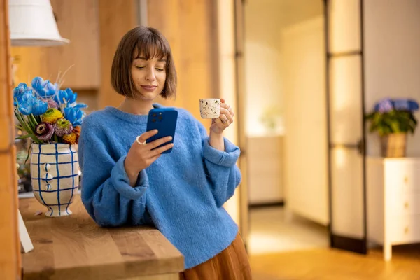 Mujer Joven Disfruta Una Bebida Café Mientras Busca Teléfono Inteligente — Foto de Stock