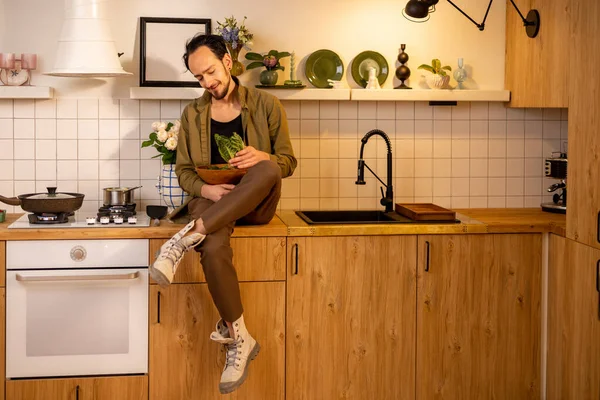 Portret Van Een Man Met Een Saladeblad Tafelblad Terwijl Hij — Stockfoto