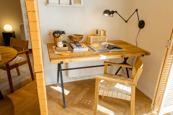 带有木制桌子的工作空间的内部视图 带有书籍的架子和时尚工作室中的灯 — 图库照片