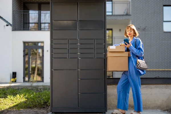 Genç Bir Kadın Otomatik Postane Makinesinden Paketleri Alıp Apartmanın Yakınında — Stok fotoğraf