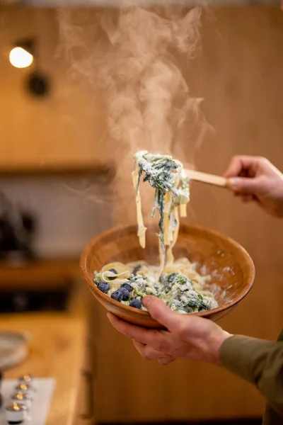 Mann Mixt Leckere Heiße Pasta Mit Blaubeeren Und Spinat Holzschüssel — Stockfoto