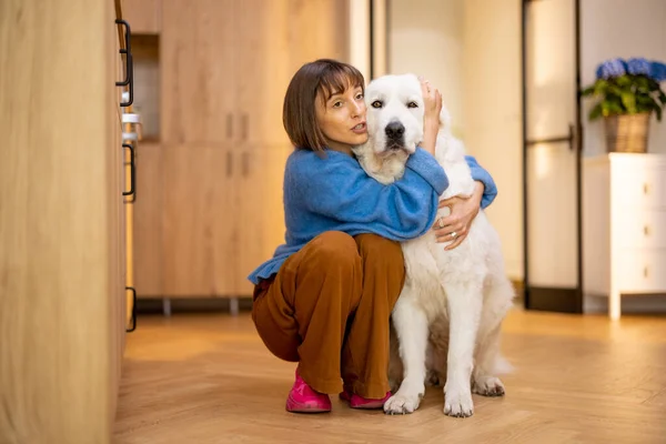 一个年轻女子和她的大白狗在家里拥抱在一起的画像 家庭生活方式的概念和与宠物的友谊 Maremma牧羊犬 — 图库照片