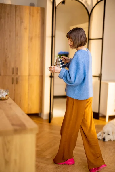 年轻女人在其现代工作室公寓的厨房里带着水壶和杯子散步 度过了一段闲暇时光 家庭生活方式和健康概念 — 图库照片