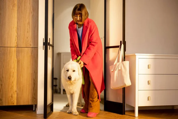 女人和她的狗散步回来 站在客厅门口的家 与宠物共度快乐时光的概念 — 图库照片