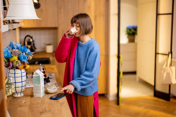 女人冲出家门 穿上外套 喝完咖啡 看了看智能手机 日常工作和繁忙工作的概念 — 图库照片