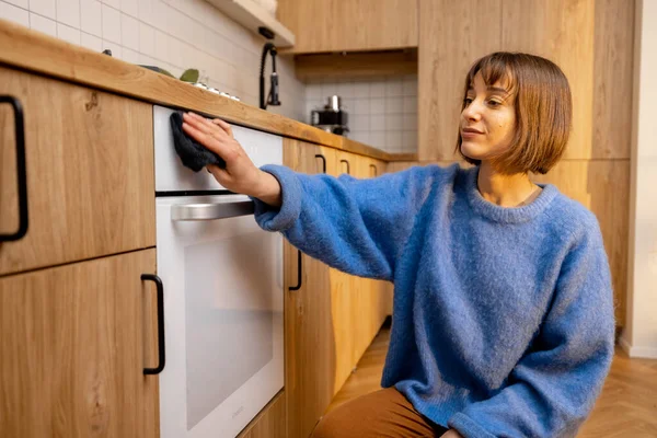 Mulher Jovem Esfrega Uma Superfície Forno Limpando Equipamento Cozinha Casa — Fotografia de Stock