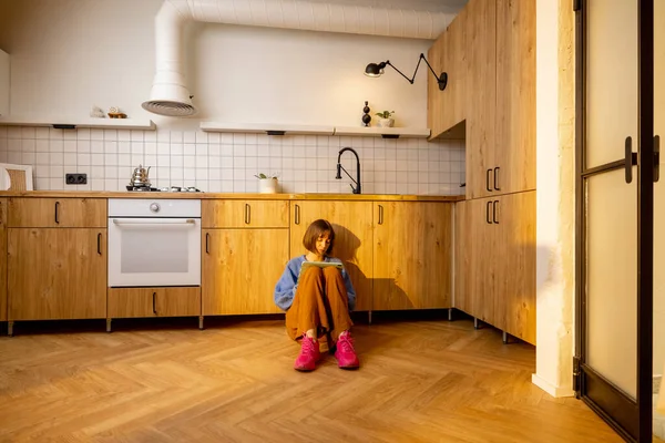 Nuori Nainen Istuu Digitaalisen Tabletin Kanssa Keittiön Lattialla Uudessa Tyylikkäässä — kuvapankkivalokuva