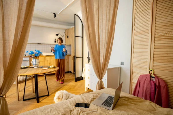 女人做一些家务活 在时尚的工作室公寓里摆餐桌 家庭舒适 风格和生活方式的概念 — 图库照片