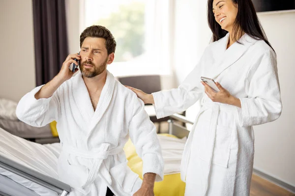 男子和妇女在医疗病房康复期间 通过电话与亲属交谈 妇女在术后在舒适的医疗套间里共同供养丈夫 — 图库照片