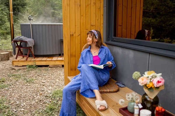女人在大自然上一座木制小屋漂亮的阳台上休息 逃避自然 平静和放松的概念 — 图库照片