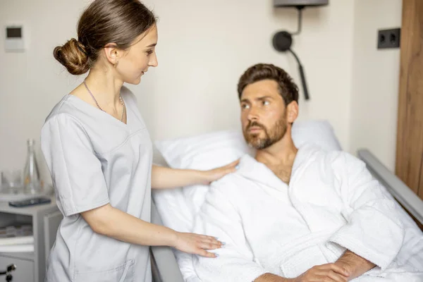 พยาบาลหน แลชายผ ใหญ นอนบนเต ยงของแผนกแพทย สะดวกสบาย การสน บสน นทางการแพทย และความช — ภาพถ่ายสต็อก