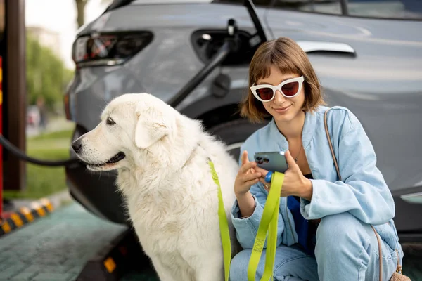 Молодая Женщина Огромной Белой Собакой Ждет Электрический Автомобиль Будет Заряжен — стоковое фото
