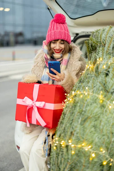 Χαρούμενη Γυναίκα Που Χρησιμοποιεί Κινητό Τηλέφωνο Ενώ Ψωνίζει Για Χειμερινές — Φωτογραφία Αρχείου