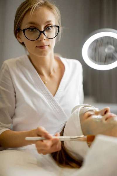 Kosmetologis Menerapkan Topeng Kecantikan Dengan Kuas Wanita Wajah Salon Kecantikan — Stok Foto