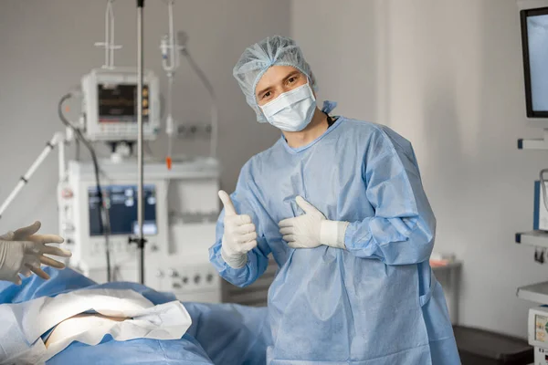 Iloisen Kirurgin Muotokuva Steriilissä Univormussa Valmiina Leikkaukseen Lähellä Potilasta Joka — kuvapankkivalokuva