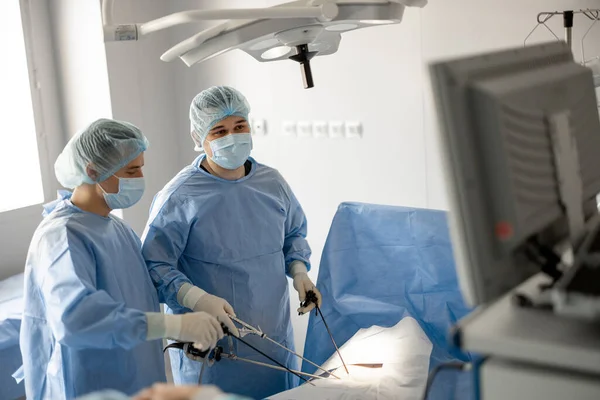 Dua Ahli Bedah Berseragam Mengoperasikan Seorang Pasien Dengan Endscopes Dan — Stok Foto