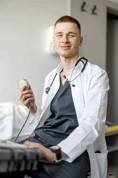 Nuori Hymyilevä Ultraäänidiagnostiikkaan Erikoistunut Lääkäri Istuu Työpaikallaan Klinikalla Oikeiden Lääkäreiden — kuvapankkivalokuva
