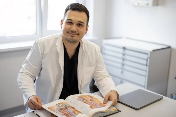 Portret Urologa Siedzącego Książką Biurze Medycznym Koncepcja Portretów Prawdziwych Lekarzy — Zdjęcie stockowe