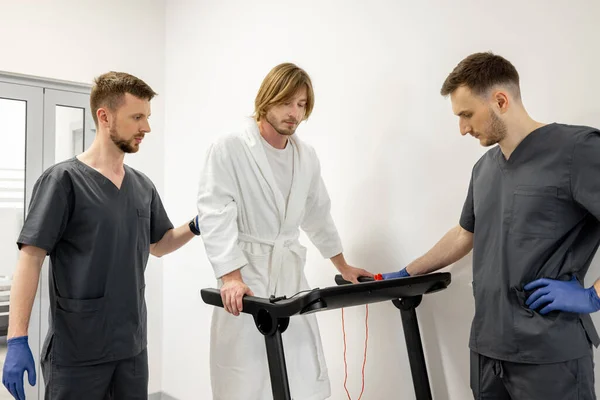 Dua Spesialis Rehabilitasi Membantu Pasien Berjalan Atas Treadmill Selama Rehabilitasi — Stok Foto