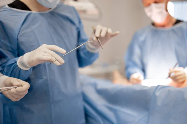 Kirurgi Pitää Kirurgisia Työkaluja Leikkauksen Aikana Lähikuva — kuvapankkivalokuva