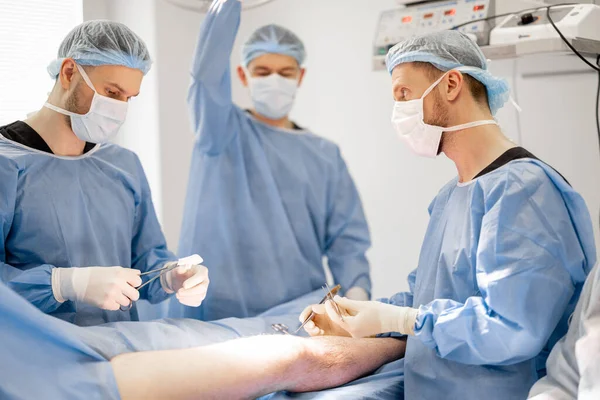 Tre Sikre Kirurger Utfører Kirurgisk Operasjon Pasientkne Operasjonsrommet Konseptet Med – stockfoto