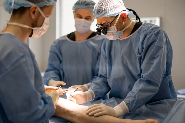 Kolme Itsevarmaa Kirurgia Jotka Suorittavat Polvileikkauksen Käsitys Todellisesta Leikkauksesta Invasiivisista — kuvapankkivalokuva