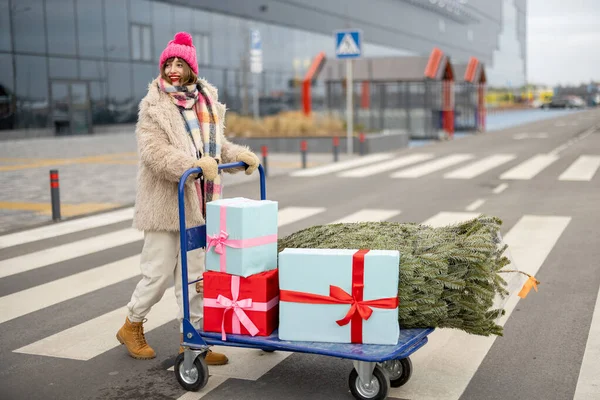 Mujer Empujando Carrito Lleno Regalos Árbol Navidad Frente Centro Comercial —  Fotos de Stock