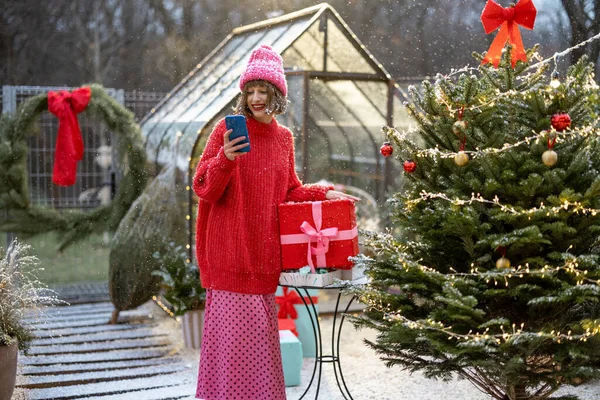 Woman Red Sweater Hat Using Mobile Phone While Standing Gift — Stock Photo, Image
