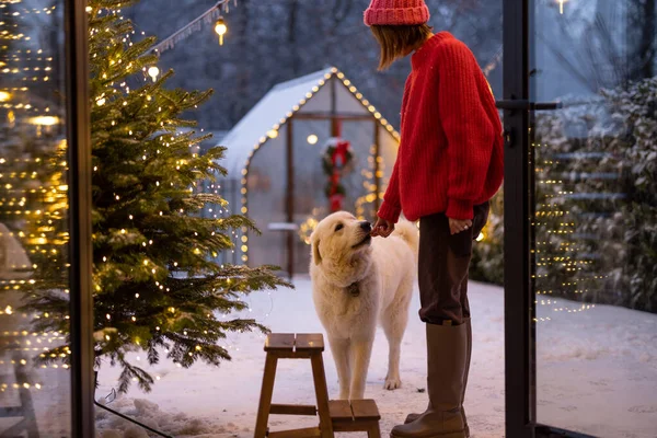 女人和她可爱的白狗在装饰精美 雪地的院子里玩耍 在寒假期间一起庆祝和玩乐 寒假快乐 魔法和爱情的概念 — 图库照片