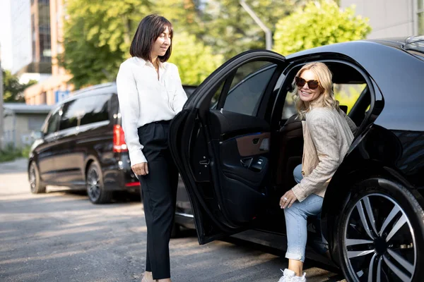 Sopir Wanita Membantu Seorang Wanita Bisnis Untuk Keluar Dari Mobil — Stok Foto