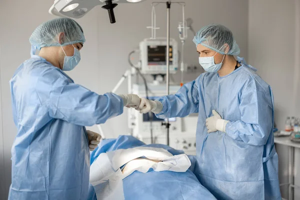 Kaksi Kirurgia Antaa Viisi Toisilleen Valmiina Leikkaukseen Käsitys Tiimityöstä Leikkauksen — kuvapankkivalokuva