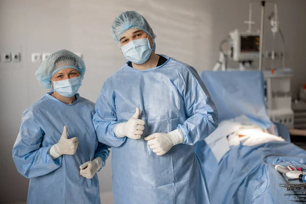 確かな外科医と看護師の肖像画は 侵襲的な治療の準備ができている手術室で一緒に立っています チームワークコンセプト — ストック写真