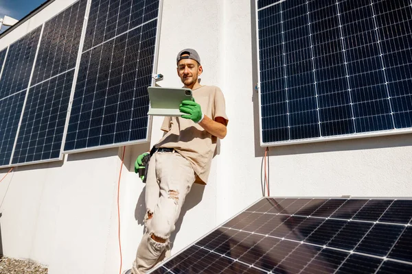 配有数字平板电脑的技术员检查新安装在房顶上的太阳能站的运行情况 太阳能发电厂的维修概念及其性能 — 图库照片