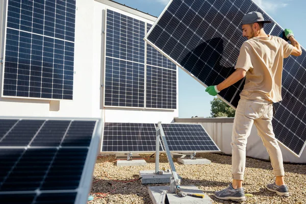 人类在其财产的屋顶上安装太阳能发电厂时携带太阳能电池板 广角镜 可再生能源促进自我消费的概念 为家庭安装面板的想法 — 图库照片