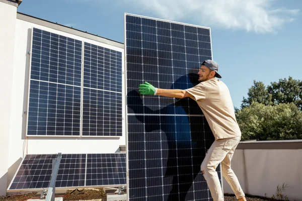 Mannen Bærer Solcellepanel Mens Han Installerer Solcelleanlegg Taket Sin Eiendom – stockfoto