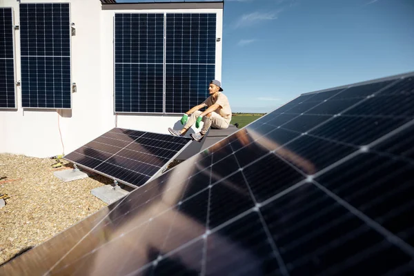 Mies Istuu Talonsa Katolla Johon Asennettu Aurinkovoimala Uusiutuvan Vihreän Energian — kuvapankkivalokuva