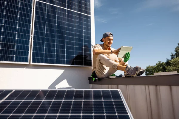Mies Istuu Katolla Käyttää Digitaalista Tablet Monitorointityötä Kiinteistöönsä Asennetusta Aurinkovoimalasta — kuvapankkivalokuva