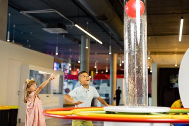 Küçük oğlan ve kız fiziği bir bilim müzesini ziyaret ederken fiziksel fenomenleri gösteren bir model üzerinde öğreniyorlar. Çocuk eğlencesi ve öğrenme kavramı