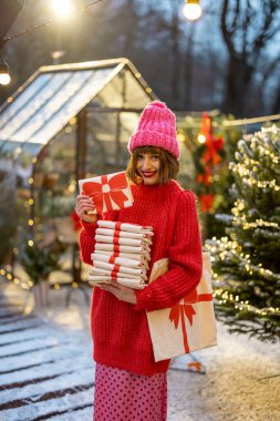 Kadının elinde üzerinde yeni yıl yayı resmi olan keten çantalar var. Yakın plan. Kış tatili için şenlikli dezenfekte kavramı