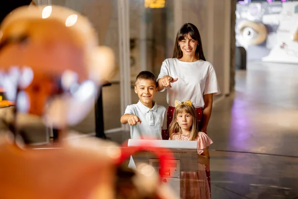 子供と一緒にいるママは 科学博物館を訪れるロボットと交流することに興奮しています 近代的な技術と児童教育の概念 — ストック写真