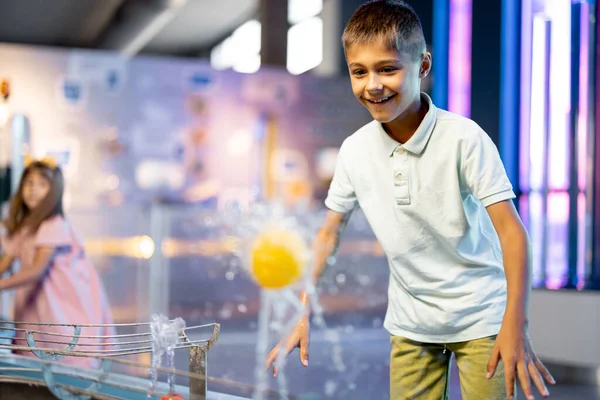 小さな男の子は水の蒸気でボールで遊び 興味深い方法で物理現象を学び インタラクティブなモデルを持つ科学博物館で楽しんでいます — ストック写真