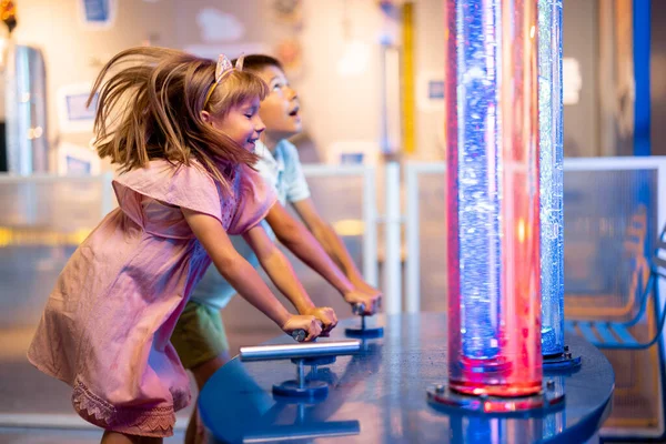 小さな子供たちは 科学博物館を一緒に訪れるインタラクティブな方法で物理現象を研究するチューブに泡をポンプします — ストック写真